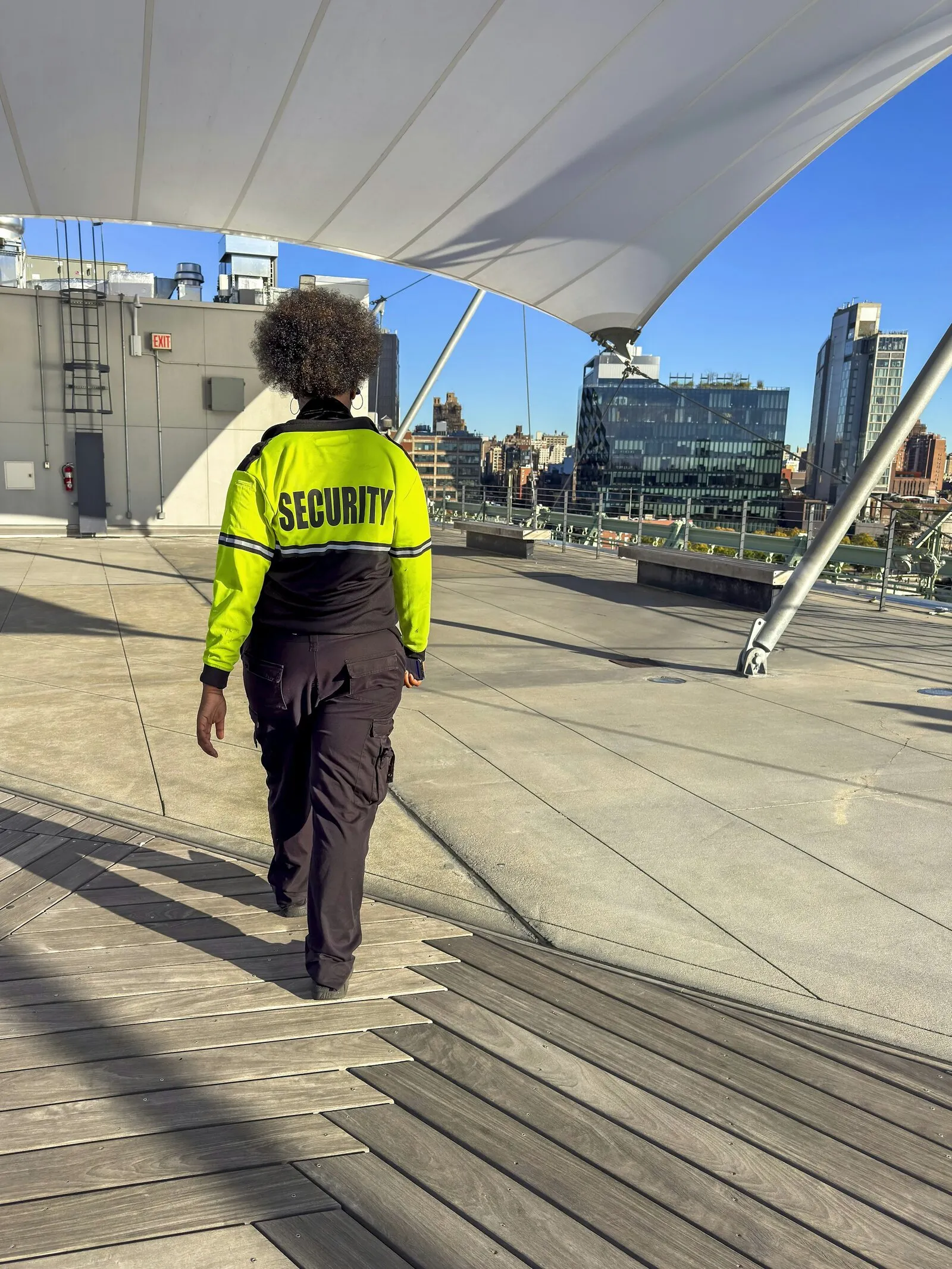 A security guard walking across a rooftop plaza