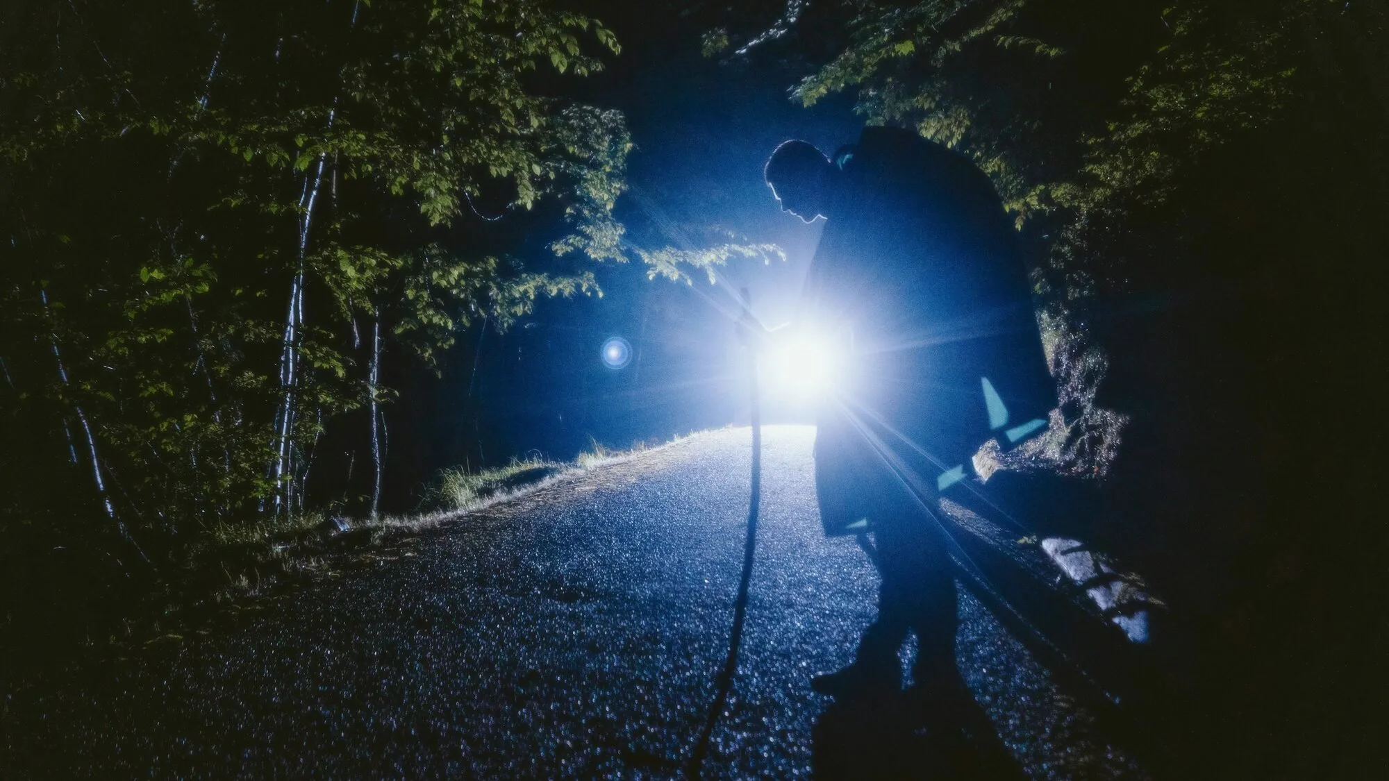 A guard on night patrol with a flashlight