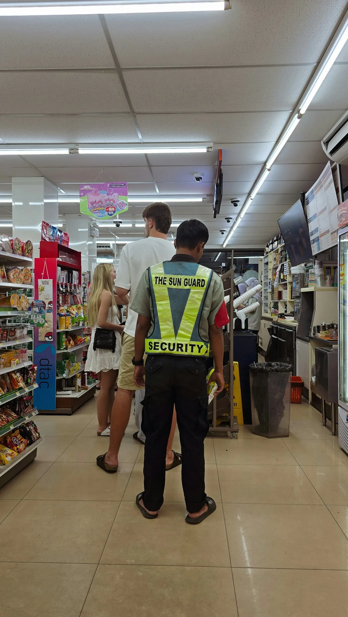 A security guard in a reflective vest in a store aisle